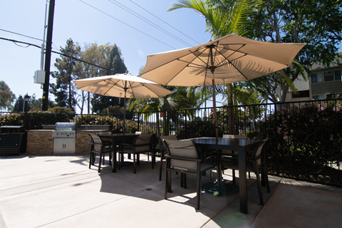 A patio with a table and chairs under a large umbrella.